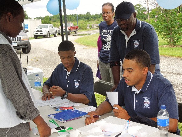 Chapter members (l-r) Corey Kinsler, Braxton Ward and William Benson question a Hampton middle school student on the journal maintained in preparation for the July unmanned aerial vehicle competition.